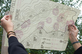 Carte réalisée en sérigraphie, ouverte tenue à deux mains, positionnée vers le ciel, effet de transparence en recto/verso